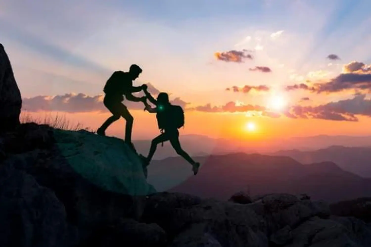 Ein Junge hilft einem Mädchen beim Bergsteigen von Malgorzata Waniek Consulting UG 